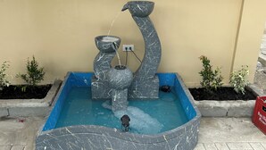A decorative water fountain with a curved design, set in a blue basin. - Spacious 9-bedroom apartment in lovely Bugallon with AC (Bugallon)