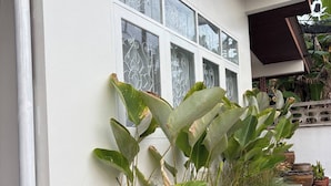 A white building with large windows and a covered porch area. - 3BR Family Villa - 1 km to Chalong Pier With Wifi (Chalong)