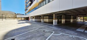 Un estacionamiento de varios niveles con marcas de carril claras y una rampa que conduce a la entrada.
