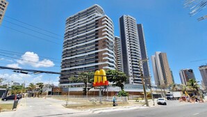 Zona urbana con rascacielos, edificios modernos, un McDonald's con servicio de autoservicio y un cielo azul despejado.