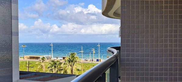 Un balcone con vista sull'oceano e un muro rivestito di piastrelle.