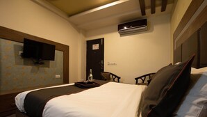A hotel room with a large bed, a flat-screen TV mounted on the wall, an air conditioning unit, and a door with a sign. - Hotel O Kinfra Industrial Park (Kozhikode)