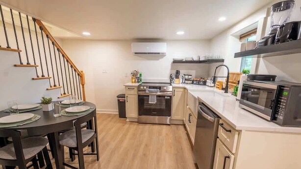 A modern kitchen with a central island, built-in oven, microwave, and dishwasher. - Stay Roanoke | Roanoke Roost | 2BR + Fire Pit (Roanoke)