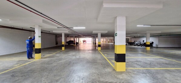 A multi-level parking garage with concrete floors and yellow and black striped pillars. - COARM0112 - Art Studio Open Spaces (Salvador)