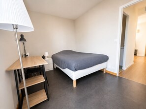A bedroom with a bed, a desk with a lamp, and a shelf. - Spacious 3-bedroom apartment in Tours Nord near the tramway (Tours)