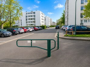 A parking lot with multiple cars and a green barrier in the foreground. - Spacious 3-bedroom apartment in Tours Nord near the tramway (Tours)