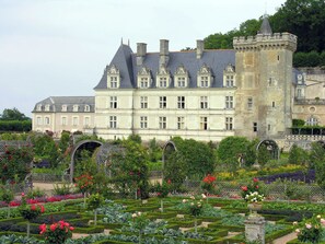 A large, historic building with multiple windows and a tower. In front, there is a well-maintained garden with various plants and flowers. - Spacious 3-bedroom apartment in Tours Nord near the tramway (Tours)