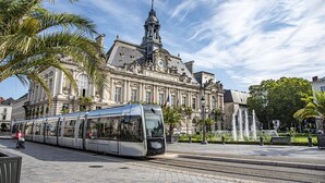 A modern tram in front of a historic building with a prominent tower and classical architecture. - Spacious 3-bedroom apartment in Tours Nord near the tramway (Tours)
