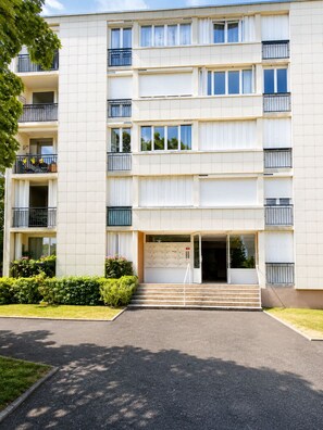 A multi-story residential building with a central entrance, balconies on each floor, and a small garden area in front. - Spacious 3-bedroom apartment in Tours Nord near the tramway (Tours)