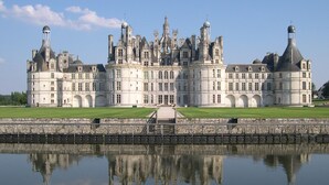 A large, historic building with multiple towers and arched windows, reflecting in a calm body of water in front. - Spacious 3-bedroom apartment in Tours Nord near the tramway (Tours)