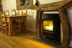 Una habitación con chimenea, sillas de madera y una mesa.