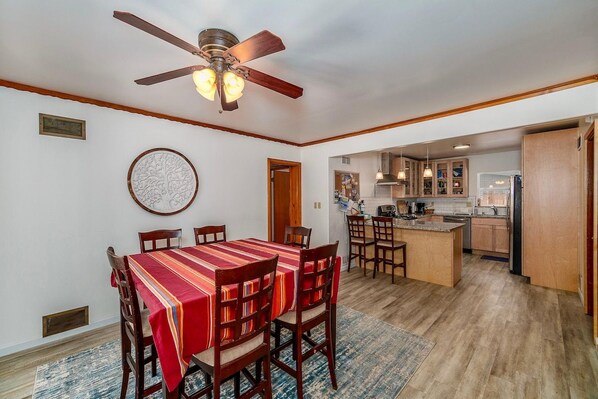 A dining area with a wooden table, chairs, and a ceiling fan. - Al Tahoe Cabin-Vintage Meets Modern 3 Bed, 2 B (South Lake Tahoe)