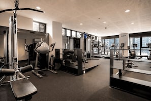A modern gym with various exercise equipment, large windows, and a high ceiling. - 23rd-Flr Docklands Views, Pool, Jacuzzi, Free Tram (Docklands)