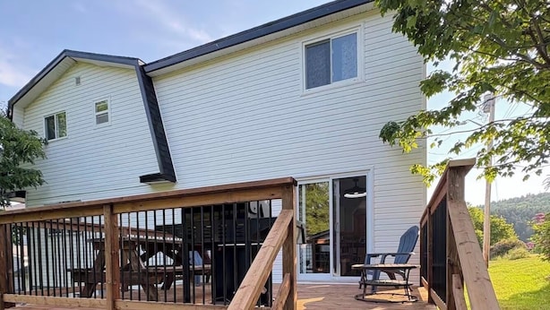 A house with a wooden deck and a covered patio area.