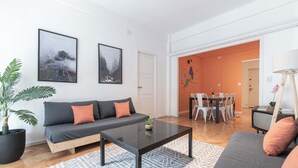 Una sala moderna con un sofá, una mesa de centro y una zona de comedor con sillas y una mesa.