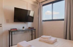 Escritorio, tabla de planchar con plancha, wifi y ropa de cama