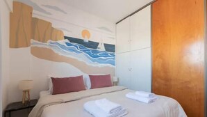 Ein Hotelzimmer mit einem Bett, Kissen, einem Nachttisch, einer Lampe und einem Holzschrank.