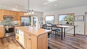Een moderne keuken met houten kasten, roestvrijstalen apparatuur en een groot eiland.