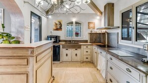 A kitchen with a central island, a built-in oven, and a modern chandelier. - Villa Soleil d'Été – Heated Pool Near Beaches and Sainte-Maxime Center (Sainte-Maxime)