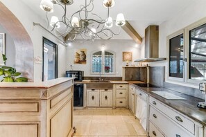 A kitchen with a central island, a built-in oven, and a modern chandelier. - Villa Soleil d'Été – Heated Pool Near Beaches and Sainte-Maxime Center (Sainte-Maxime)
