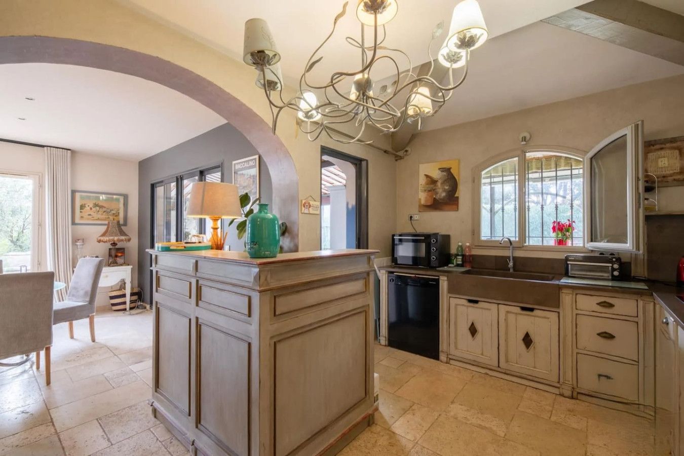 A kitchen with a central island, a built-in oven, a microwave, and a sink.