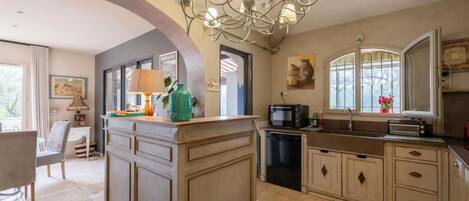 A kitchen with a central island, a built-in oven, a microwave, and a sink.