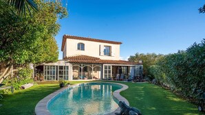 A two-story house with a swimming pool, surrounded by well-maintained grass and trees. - Villa Soleil d'Été – Heated Pool Near Beaches and Sainte-Maxime Center (Sainte-Maxime)