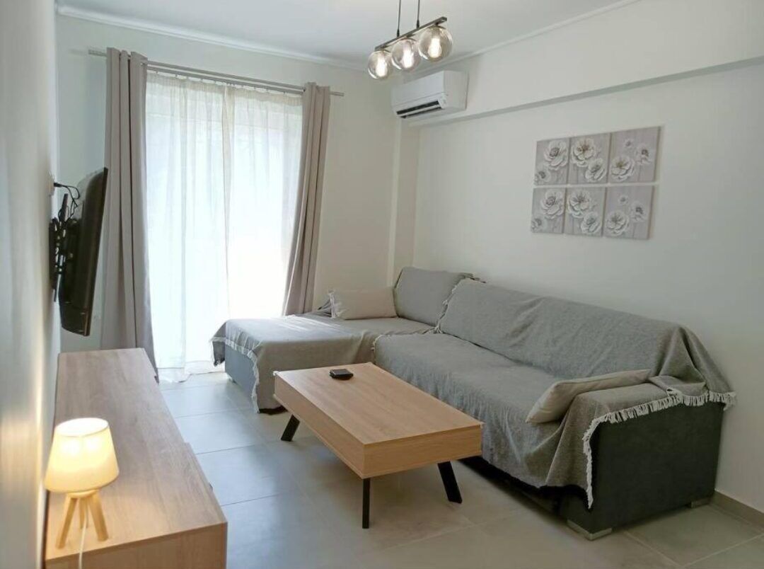 Un salon moderne avec un canapé, une table basse en bois et une lampe.