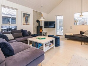 Un salon moderne avec un canapé, une table basse et un téléviseur.