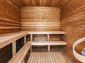 Un sauna avec des bancs en bois et une banquette.