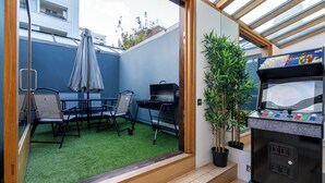 Quarto com área de refeições, churrasqueira e máquina de vendas automáticas.