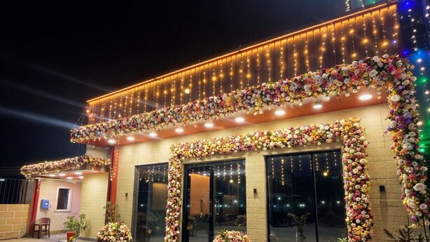 A building with a brick facade, large glass windows, and a series of lights along the roofline. - Amantran Palace (Mohania)