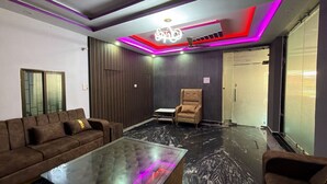 A modern living room with a sofa, armchair, and glass coffee table. - Amantran Palace (Mohania)