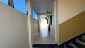 A narrow hallway with a marble staircase on the right, leading to a landing. - Amantran Palace (Mohania)