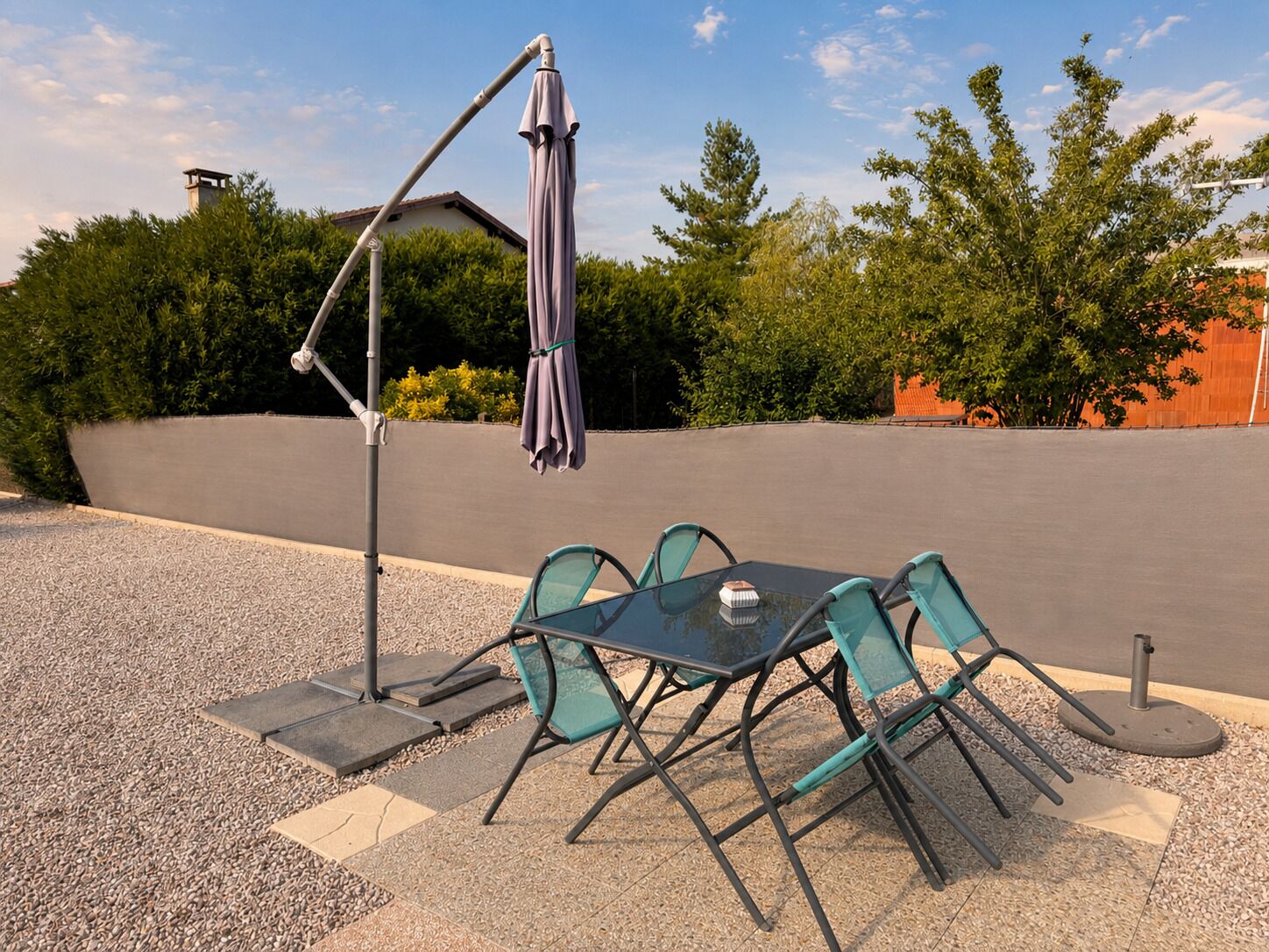 An outdoor patio with a table and chairs, a patio umbrella, and a pergola.
