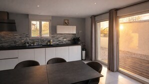 Una cocina moderna con zona de comedor, ventanas amplias y vistas al exterior.