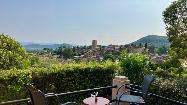 Zona salotto all'aperto con vista su un borgo storico.