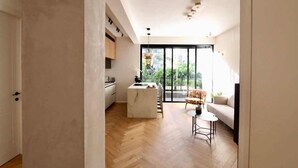 Ein modernes Interieur mit einer Küche, einem Essbereich und einer großen Schiebeglasdoor zum Balkon.
