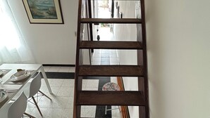 Una escalera de madera en una habitación con comedor.