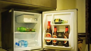 Un réfrigérateur ouvert contenant des boissons et une bouteille d’eau.