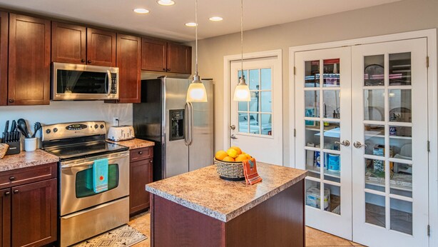 A kitchen with wooden cabinets, stainless steel appliances, a granite countertop, and a fruit basket. - Walk to Old Town! Pool, Arcade & Mini Golf - 6 beds (Scottsdale)
