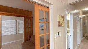 A hallway with a wooden door, a bench, and a wall-mounted artwork. - Spacious 3 Bedroom, 2 Bath Canal Home in the Heart of Tavernier (Tavernier)