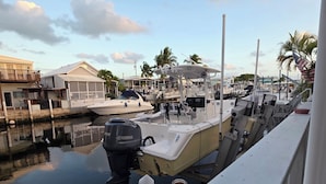A marina with boats docked, a bottle of Modelo beer on a railing, and a clear sky. - Spacious 3 Bedroom, 2 Bath Canal Home in the Heart of Tavernier (Tavernier)