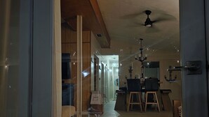 A hallway leading to a dining area with a ceiling fan, wooden flooring, and a visible door frame. - Spacious 3 Bedroom, 2 Bath Canal Home in the Heart of Tavernier (Tavernier)