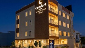 Ein mehrstöckiges Hotelgebäude mit einem gut sichtbaren Schild für 'Comfort Inn by Choice Hotels BRAJ'.