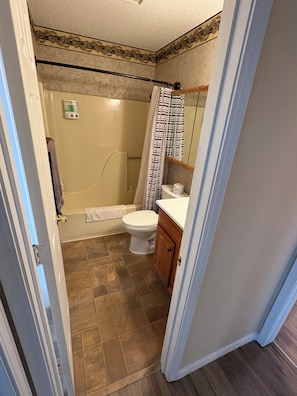 A bathroom with a shower, toilet, and sink. - Cozy 2-bedroom condo in fantastic Pointe Royale Branson location (Branson)