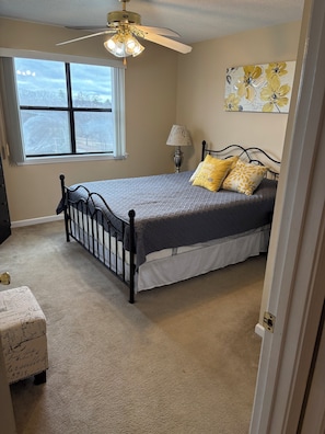 A bedroom with a bed, a ceiling fan, a window, and a lamp. - Cozy 2-bedroom condo in fantastic Pointe Royale Branson location (Branson)
