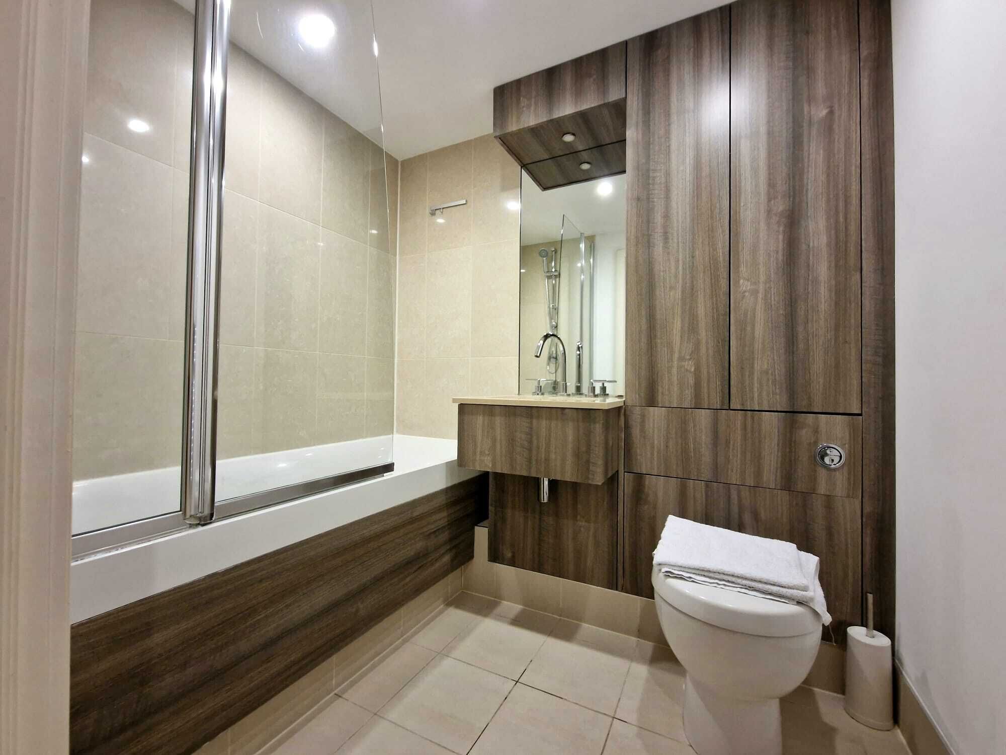A modern bathroom with a bathtub, a sink, and a toilet.