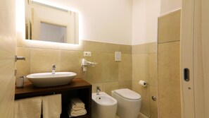 Ein Badezimmer mit Waschbecken, Bidet, Toilette und Handtuchhalter.