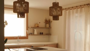 A modern kitchen with a central island, pendant lights, and a dining area with chairs. - New apartment "La vieille maison", near Serre Chevalier (Villar-Saint-Pancrace)
